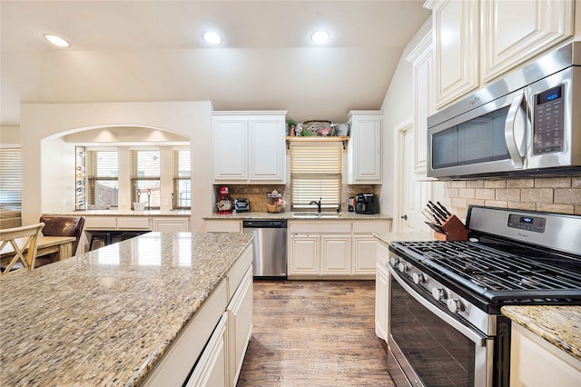 kitchen featuring appliances with stainless steel finishes, backsplash, light hardwood / wood-style floors, and white cabinetry