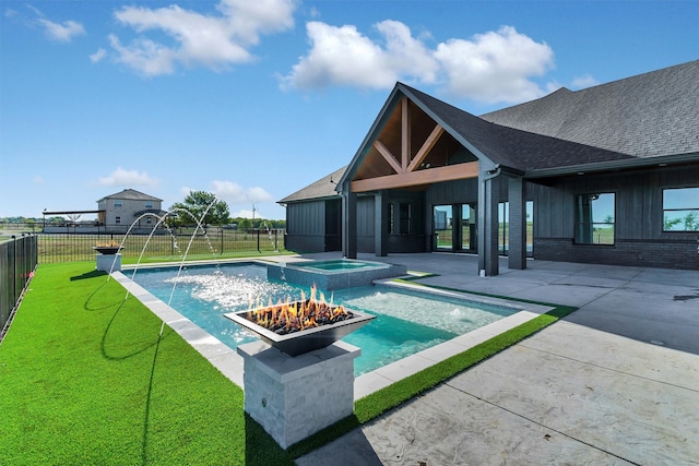 view of swimming pool with a fire pit, an in ground hot tub, a patio area, pool water feature, and a lawn