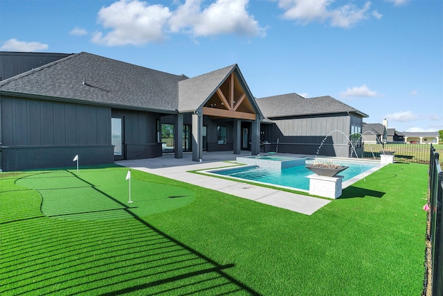 rear view of house featuring a pool with hot tub, a lawn, a patio area, and pool water feature