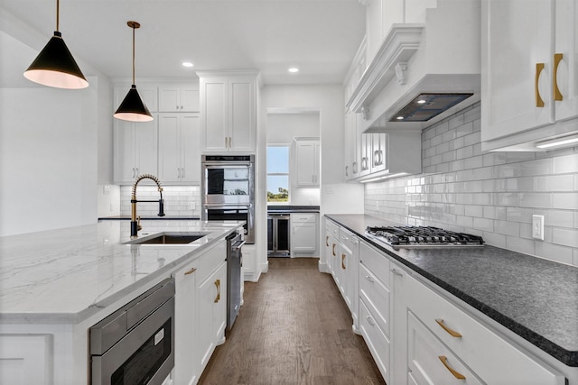5360 Moncrief Rd, Justin, TX 76247 - kitchen featuring white cabinets, tasteful backsplash, custom range hood, a sink, and stainless steel appliances