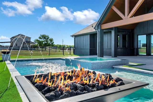 view of swimming pool featuring a yard, an in ground hot tub, and pool water feature