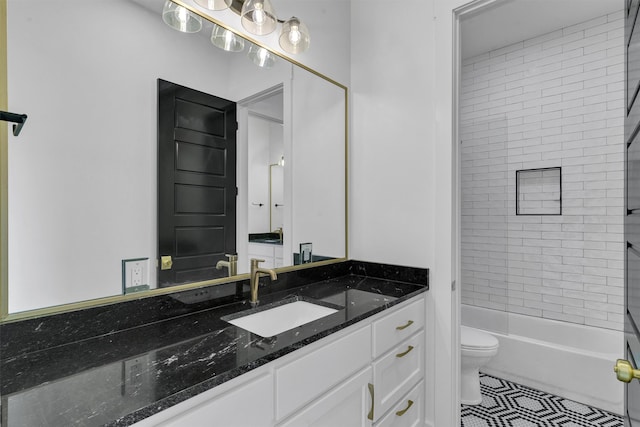 full bathroom with tiled shower / bath, vanity, and toilet