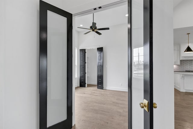 hallway featuring light hardwood / wood-style floors and a high ceiling