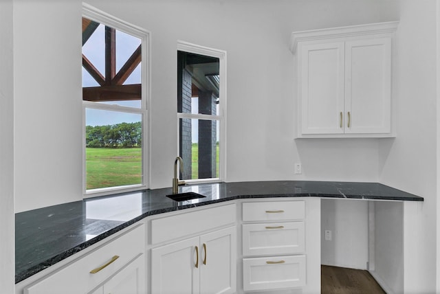 5360 Moncrief Rd, Justin, TX 76247 - kitchen with dark stone counters, dark wood-style flooring, white cabinets, and a sink