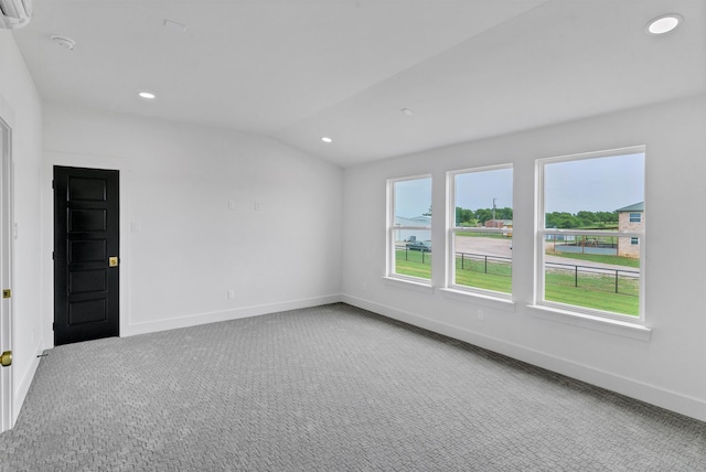 unfurnished room featuring carpet floors and vaulted ceiling