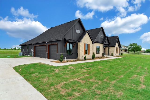 view of front facade with central AC, a front lawn, and a garage