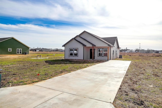 view of front of property featuring a front yard and cooling unit