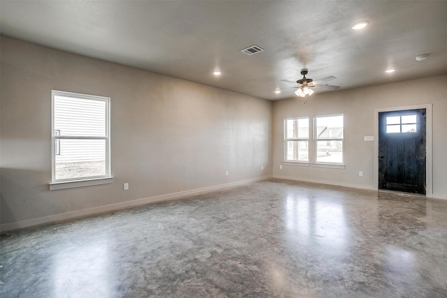 interior space featuring concrete floors, ceiling fan, and a healthy amount of sunlight