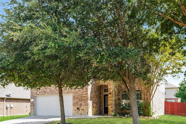 obstructed view of property featuring a front lawn and a garage