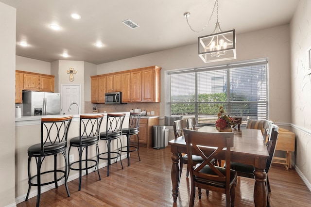 dining space featuring hardwood / wood-style flooring and a notable chandelier