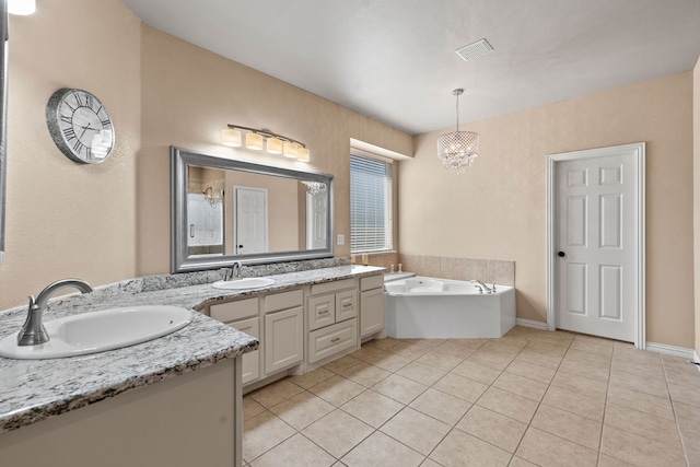 bathroom with tile patterned flooring, vanity, a notable chandelier, and a washtub