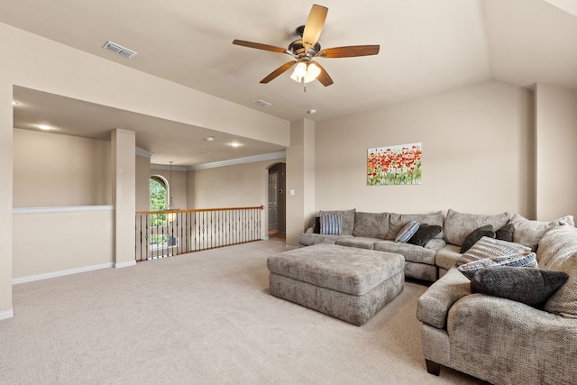 living room with ceiling fan, crown molding, and light carpet