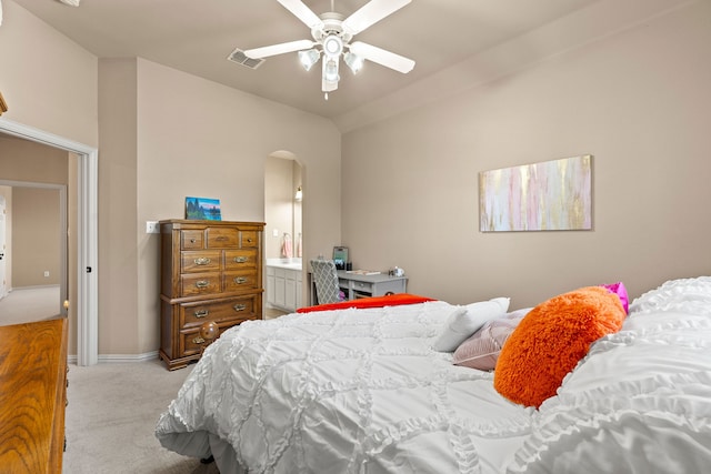 bedroom featuring connected bathroom, light colored carpet, ceiling fan, and lofted ceiling