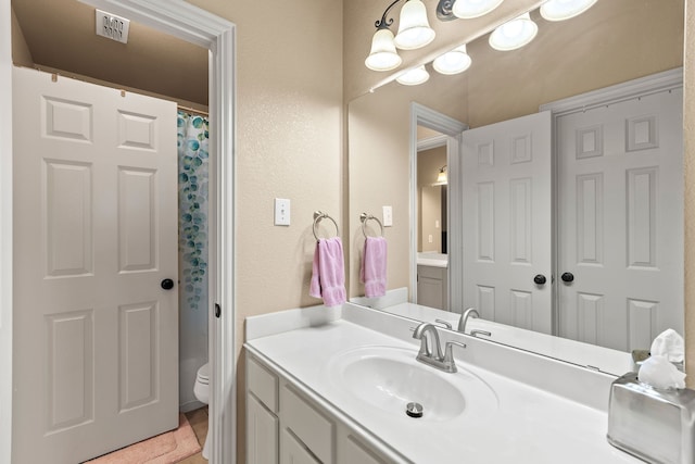 bathroom with vanity, a shower with shower curtain, and toilet