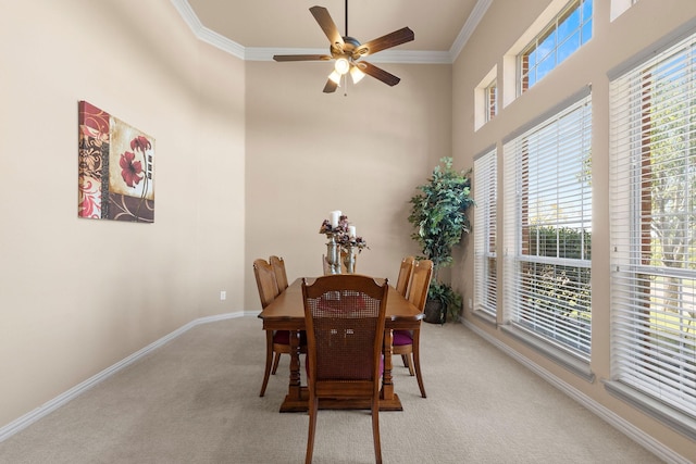 carpeted dining area with crown molding and ceiling fan