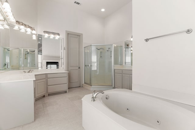 bathroom featuring vanity, a high ceiling, tile patterned floors, and separate shower and tub