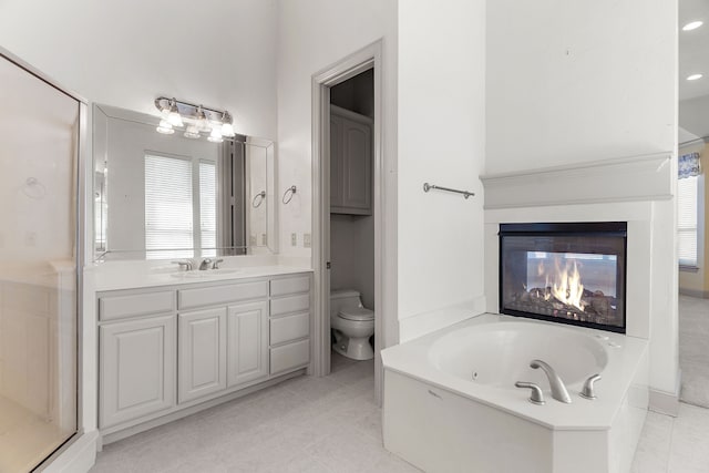 full bathroom featuring toilet, shower with separate bathtub, vanity, and plenty of natural light