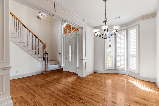 foyer entrance featuring crown molding, a notable chandelier, and wood-type flooring