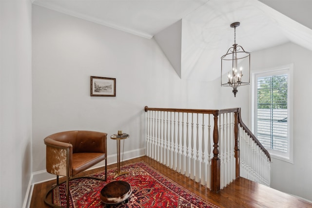 staircase featuring ornamental molding, an inviting chandelier, lofted ceiling, and hardwood / wood-style floors