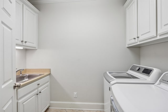 laundry area with cabinets, sink, washer and dryer, and light tile patterned flooring