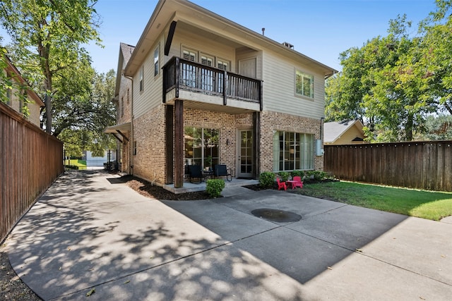 rear view of property with a balcony and a patio