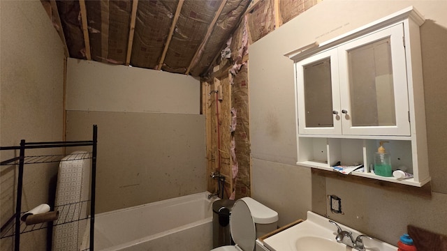 bathroom with a tub to relax in, sink, and toilet