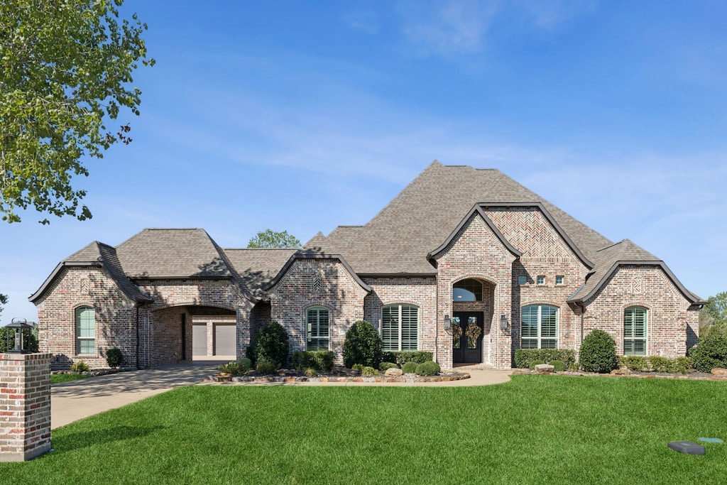 french provincial home with a front yard