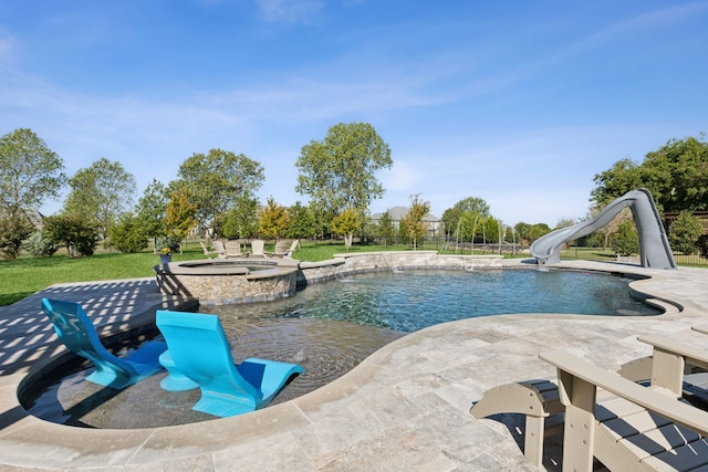 view of pool with an in ground hot tub, a water slide, and a patio