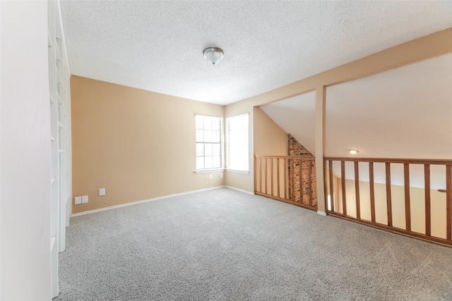 carpeted empty room with a textured ceiling and lofted ceiling