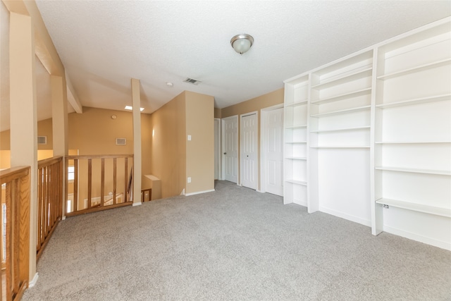 interior space with light carpet and a textured ceiling