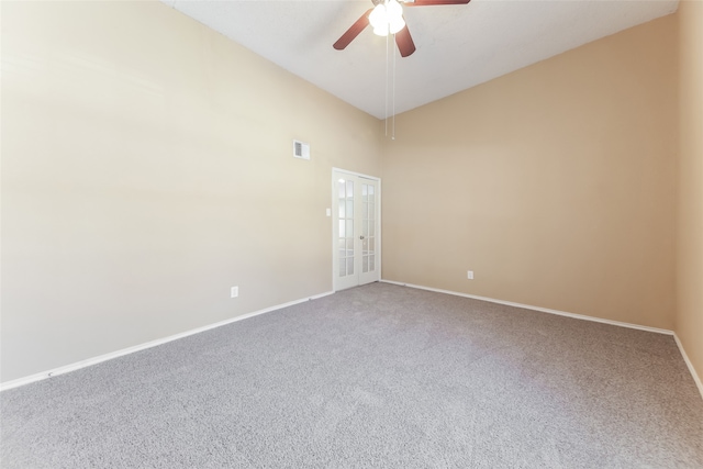 carpeted spare room with french doors, a high ceiling, and ceiling fan