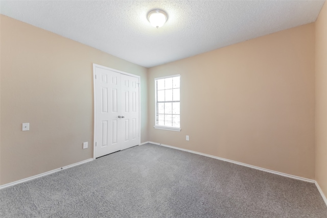 unfurnished room featuring carpet floors and a textured ceiling