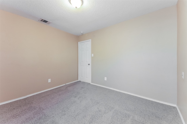 carpeted empty room with a textured ceiling