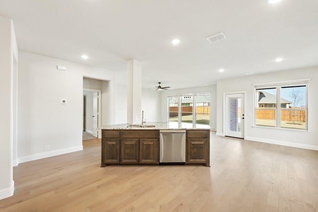 kitchen with dishwasher, sink, a kitchen island with sink, and light hardwood / wood-style flooring