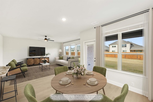 dining space with light wood-type flooring and ceiling fan