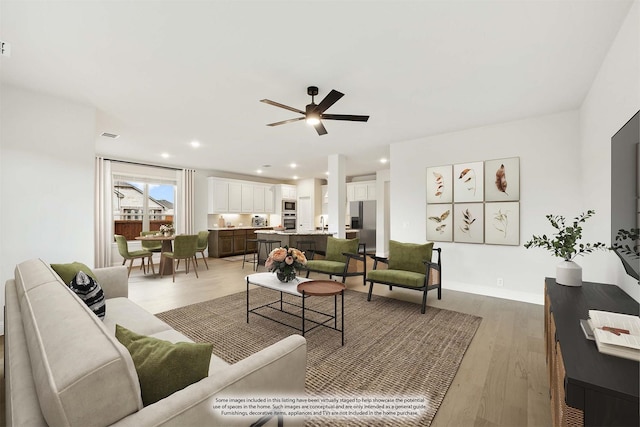 living room featuring light hardwood / wood-style flooring and ceiling fan