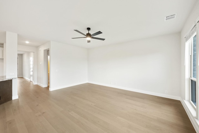 spare room with ceiling fan, light hardwood / wood-style flooring, and a healthy amount of sunlight