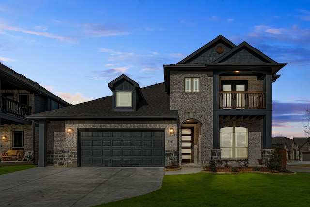 view of front facade with a yard, a balcony, and a garage