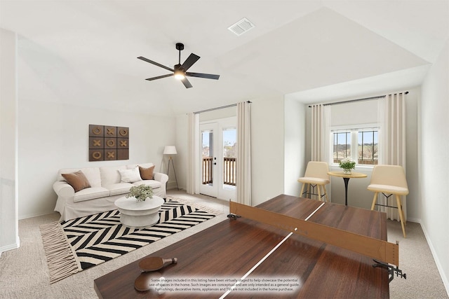 living room with ceiling fan, light colored carpet, and lofted ceiling