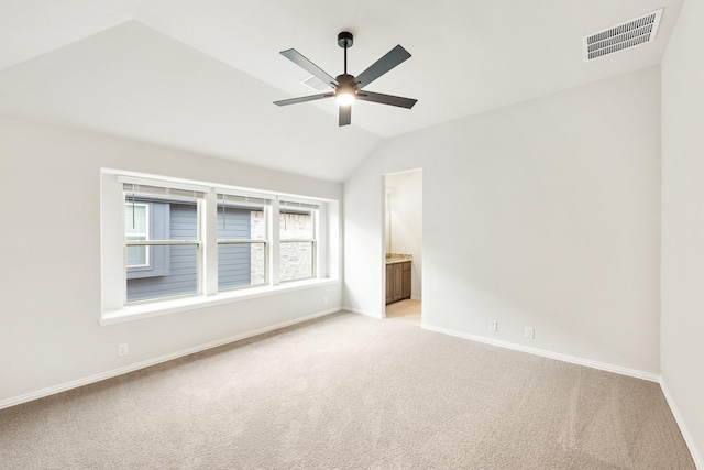 carpeted empty room featuring ceiling fan and lofted ceiling