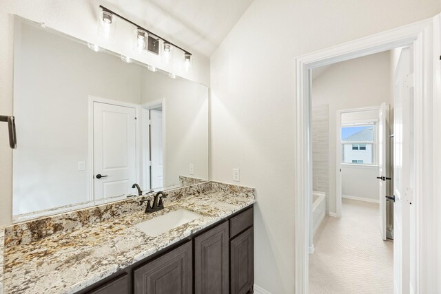 bathroom featuring vanity and vaulted ceiling