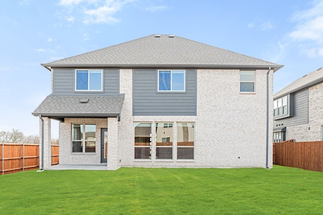 rear view of house featuring a patio area and a yard