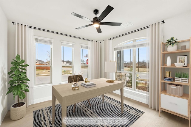 home office with ceiling fan and light hardwood / wood-style floors