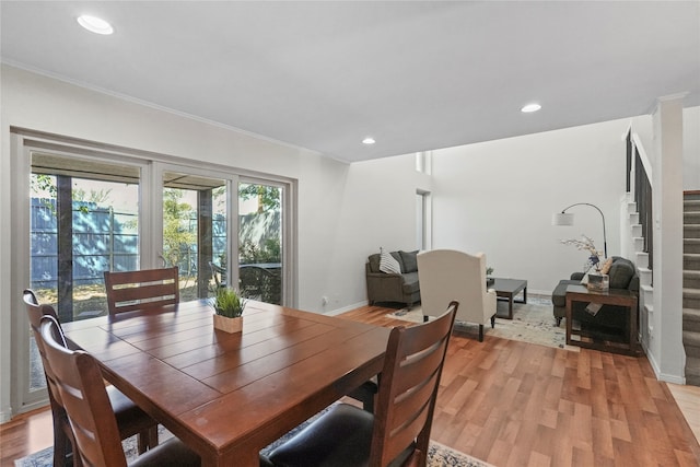 dining space featuring light wood-type flooring and crown molding