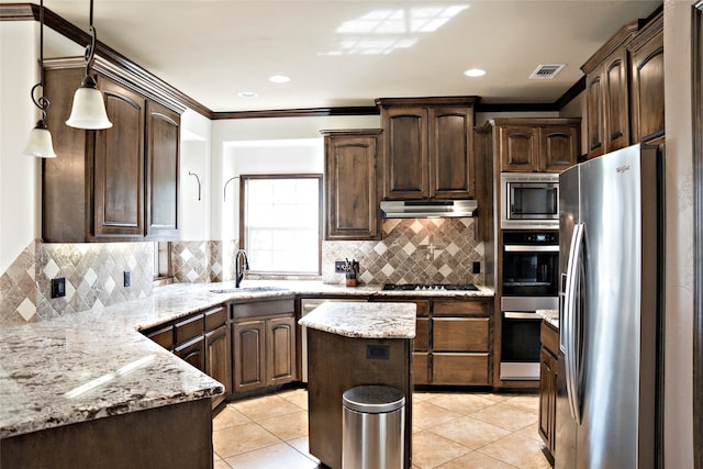 kitchen featuring light stone counters, hanging light fixtures, ornamental molding, backsplash, and stainless steel appliances