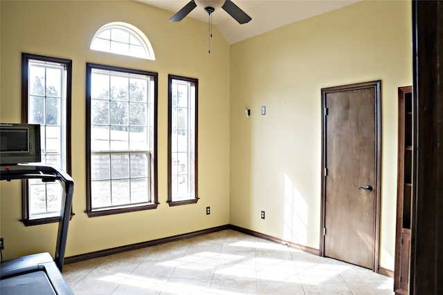 interior space with light tile patterned flooring, vaulted ceiling, and ceiling fan