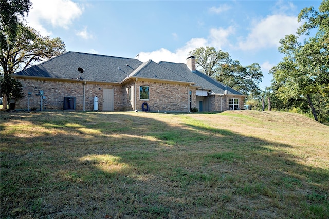 back of house featuring a yard and central AC unit