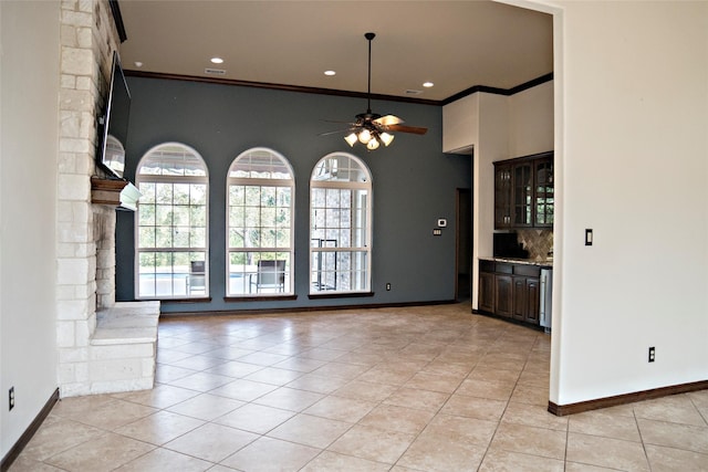 7226 County Road 1504, Athens, TX 75751 - unfurnished dining area with light tile patterned floors, crown molding, a ceiling fan, baseboards, and a towering ceiling