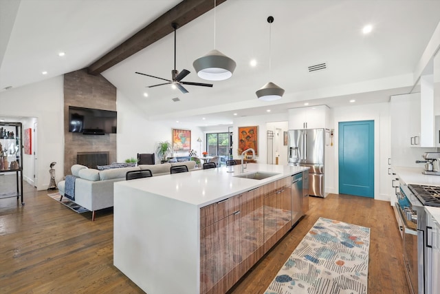 kitchen featuring stainless steel appliances, white cabinetry, hardwood / wood-style flooring, and a kitchen island with sink