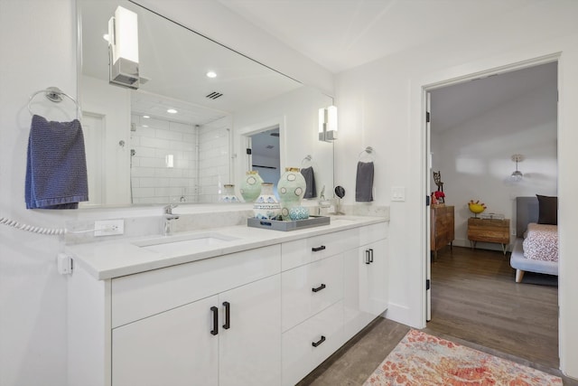 bathroom featuring tiled shower, vanity, and hardwood / wood-style floors